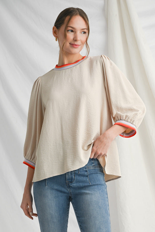 Oatmeal colored blouse with puff sleeves and red and white contrast trim