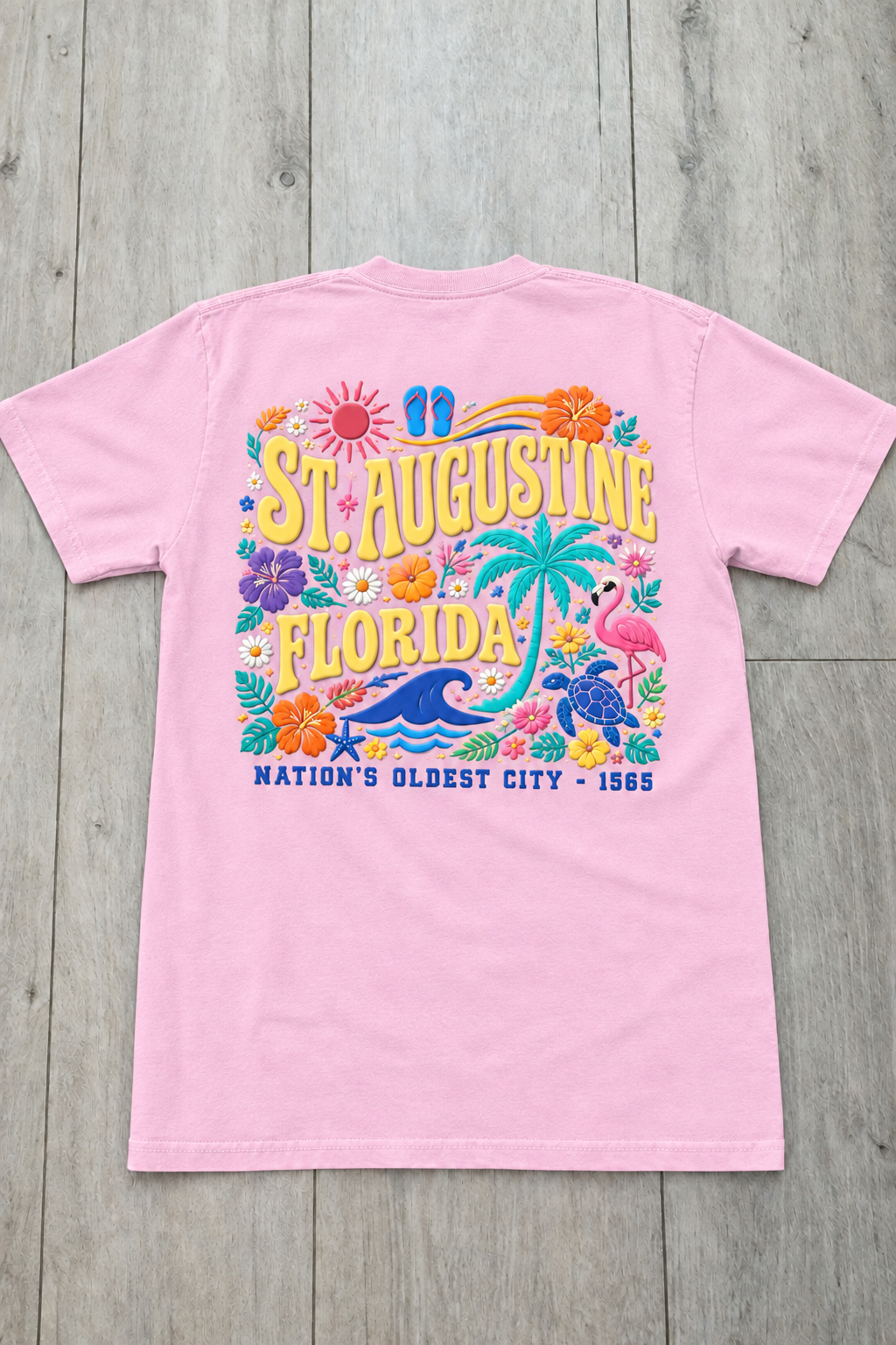 Back of lavender St. Augustine Florida t-shirt with colorful tropical floral design, palm tree, sea turtle, and “Nation’s Oldest City - 1565” text.