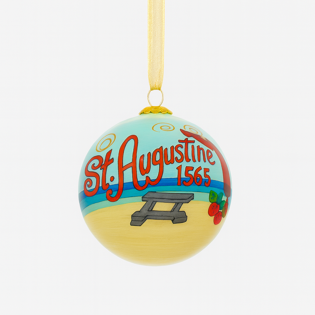 Hand-painted glass Christmas ornament with “St. Augustine 1565” lettering, beach scene artwork, and gold hanging ribbon photographed on a clean white background.