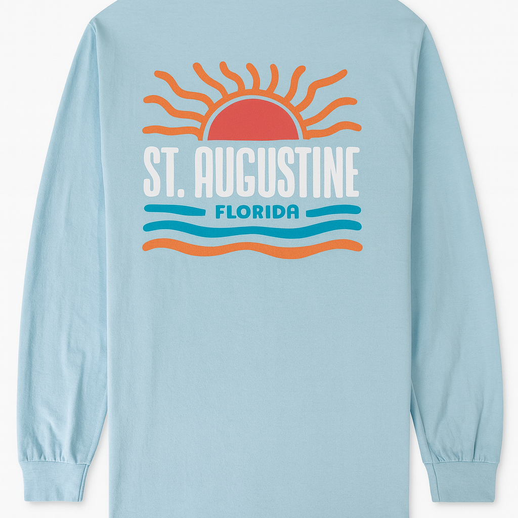 Light blue cotton long sleeve shirt with raised puffy decal design featuring a sunrise, waves, and bold St. Augustine Florida text.