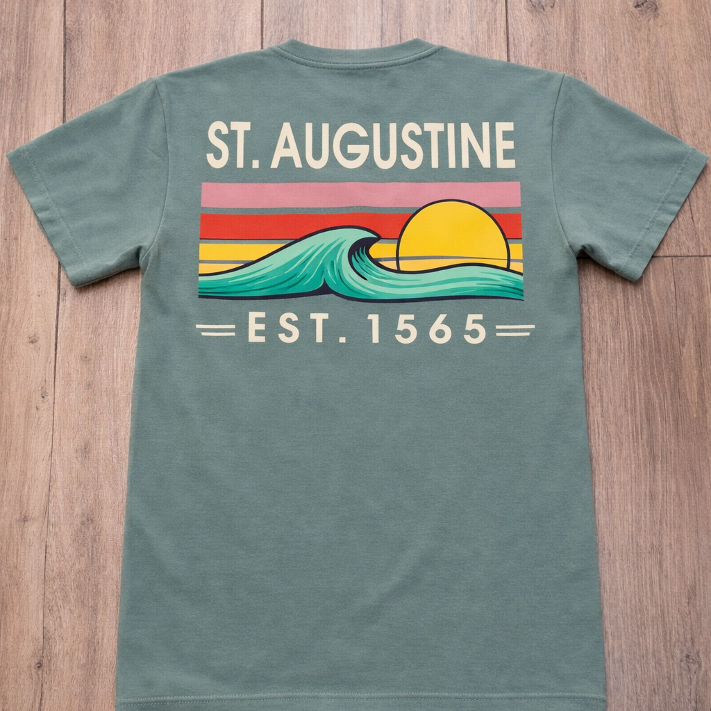 Sage St. Augustine graphic tee with retro sunset stripes, wave design, and Est. 1565 text. A beachy Florida souvenir shirt for everyday wear. Available online or in store at Artsy Abode located in historic downtown St Augustine.
