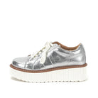 Metallic silver lace-up flatform sneaker with textured white platform sole photographed on a white background.