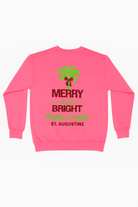 Bright pink sweatshirt with glittery red and green “Merry & Bright Nights of Lights St. Augustine” design and palm tree with bow.